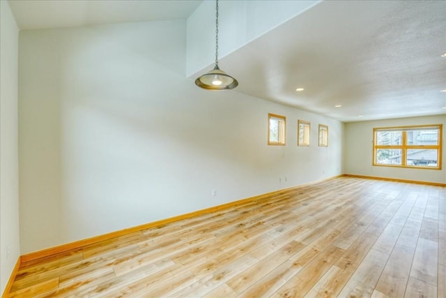 empty room featuring recessed lighting, light wood-type flooring, and baseboards