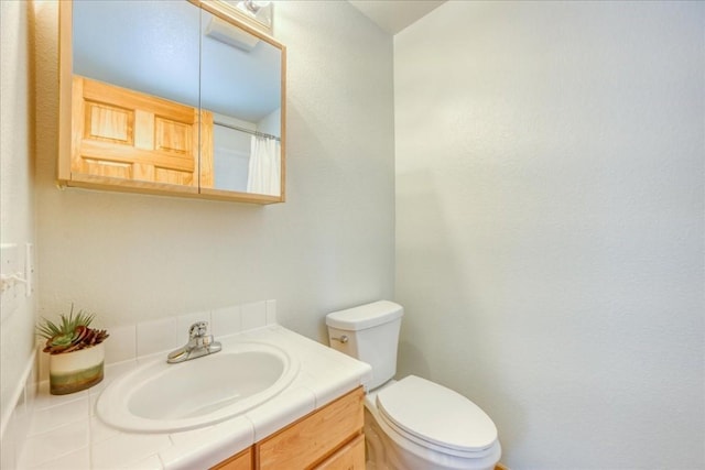 full bathroom with toilet and vanity