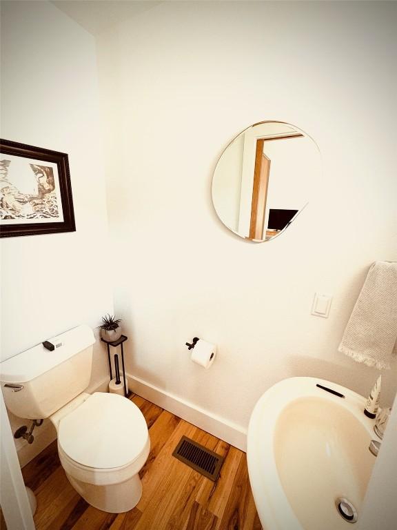 bathroom with hardwood / wood-style flooring, toilet, and sink