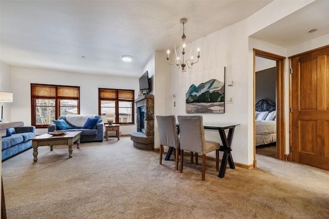 living area with carpet floors, a fireplace with raised hearth, baseboards, and an inviting chandelier