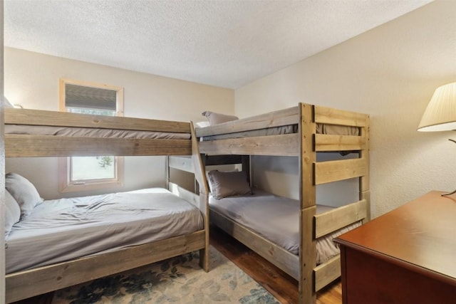 bedroom with a textured ceiling and wood finished floors