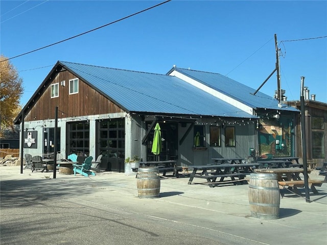 view of home's community featuring a patio area and a detached garage