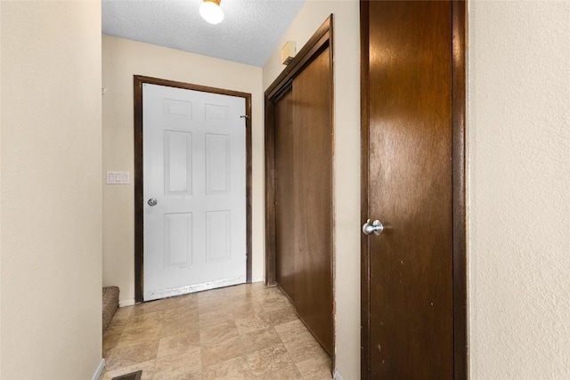 corridor featuring a textured ceiling