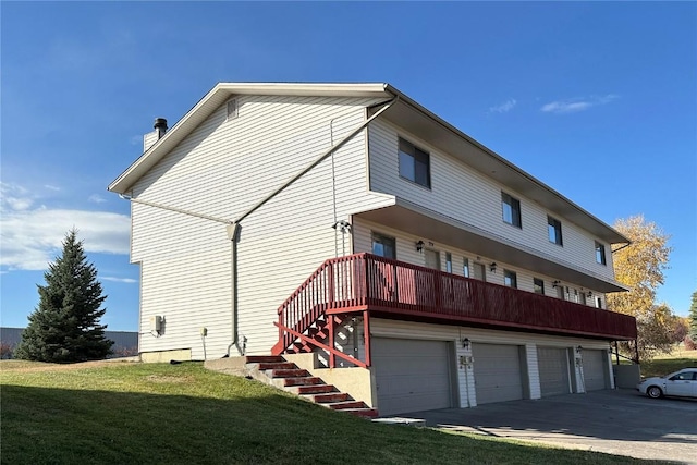 back of house featuring a lawn and a garage