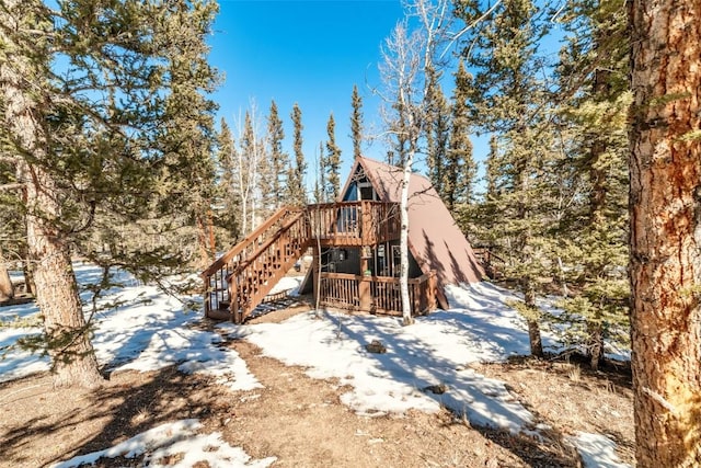 snow covered property with stairway