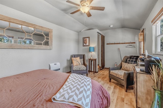 bedroom with light wood-style floors and vaulted ceiling