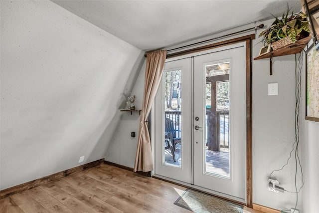 entryway featuring french doors, baseboards, and light wood finished floors