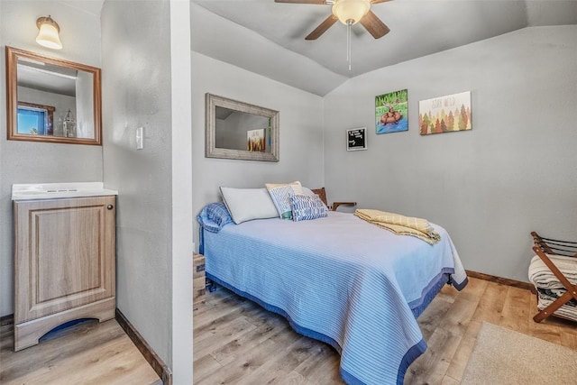 bedroom with lofted ceiling, light wood-style flooring, baseboards, and a ceiling fan