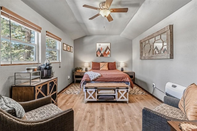 bedroom with a ceiling fan, lofted ceiling, and wood finished floors