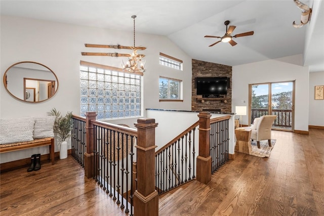 hallway with baseboards, vaulted ceiling, an inviting chandelier, and wood finished floors