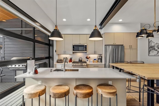 kitchen featuring high end appliances, sink, decorative backsplash, and a breakfast bar