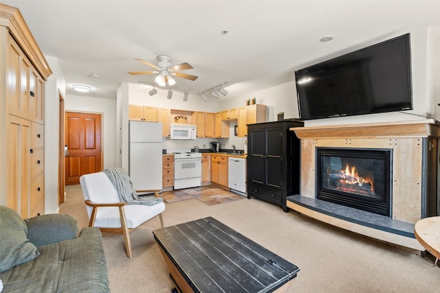 living room with ceiling fan, a glass covered fireplace, and light colored carpet