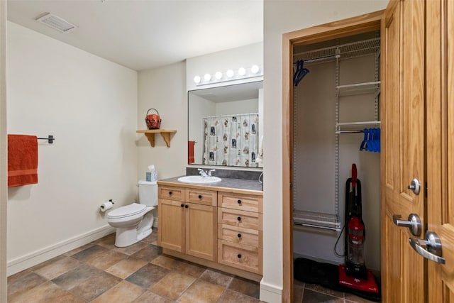 full bathroom with a closet, visible vents, toilet, vanity, and baseboards