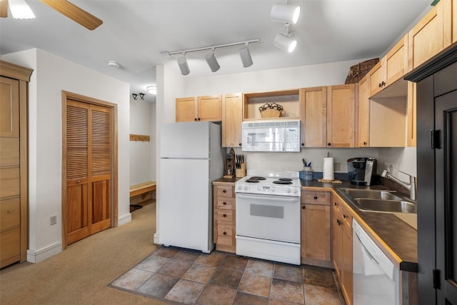 kitchen featuring white appliances, light brown cabinetry, sink, and dark colored carpet