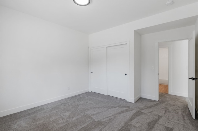 unfurnished bedroom with light carpet and a closet