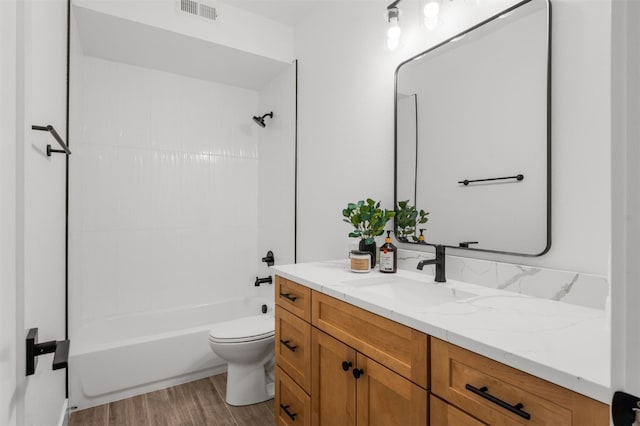 full bathroom with hardwood / wood-style floors, vanity, toilet, and washtub / shower combination