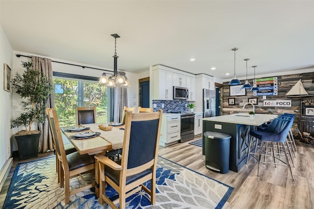 dining area with sink and light hardwood / wood-style flooring