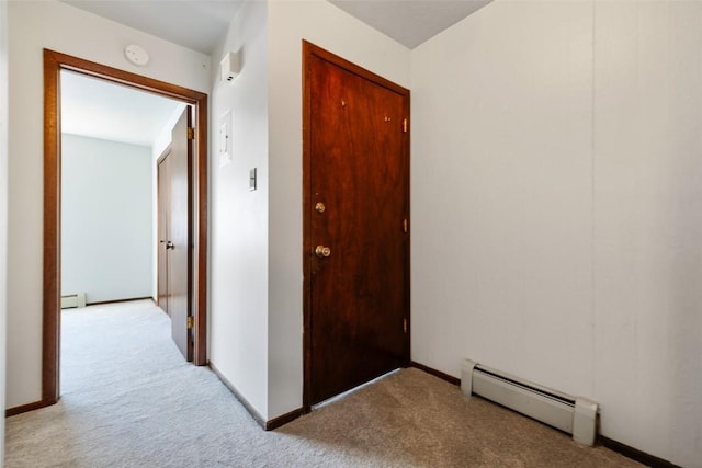 hall with light carpet and a baseboard heating unit