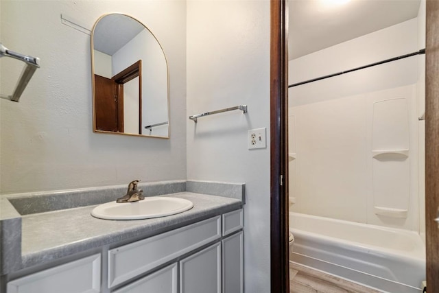 bathroom with hardwood / wood-style floors, vanity, and shower / bathtub combination