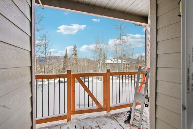 view of snow covered back of property