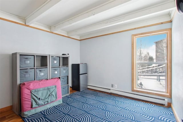 bedroom with beam ceiling, baseboard heating, and stainless steel refrigerator