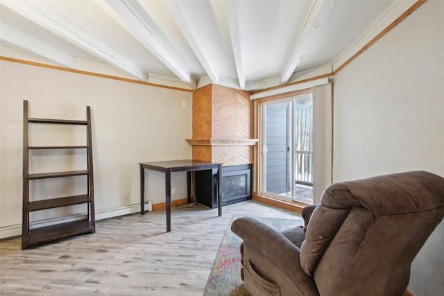 sitting room with beam ceiling, light wood-type flooring, ornamental molding, and a tiled fireplace