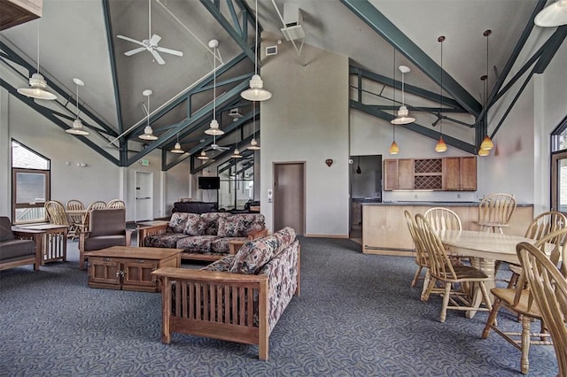 carpeted living room with ceiling fan and high vaulted ceiling