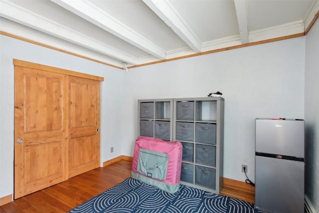 interior space with beam ceiling, wood-type flooring, and a baseboard radiator