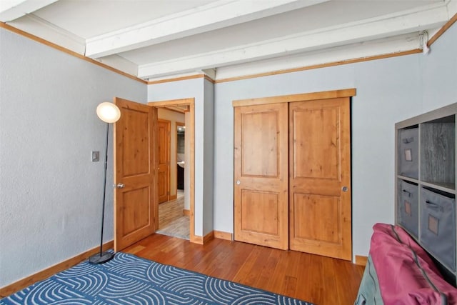 unfurnished bedroom with hardwood / wood-style flooring, a closet, and crown molding