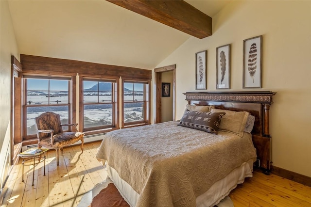 bedroom featuring lofted ceiling with beams and light hardwood / wood-style floors