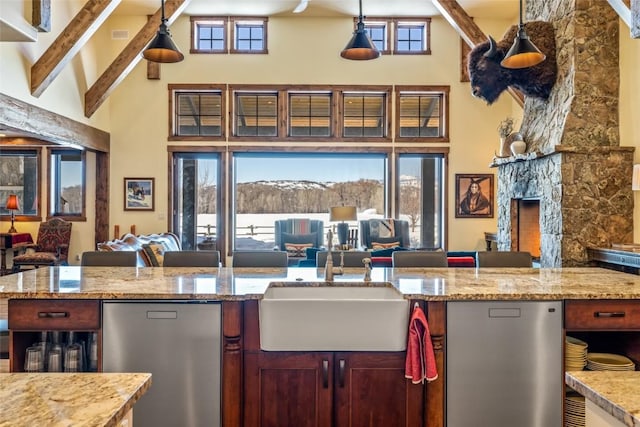 kitchen featuring sink, high vaulted ceiling, light stone countertops, decorative light fixtures, and beamed ceiling