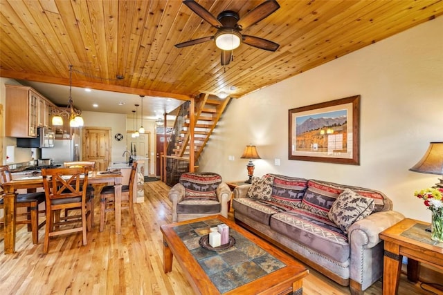 living room with ceiling fan with notable chandelier, light wood-type flooring, and wood ceiling