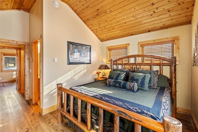 bedroom with lofted ceiling, light wood-type flooring, and wooden ceiling