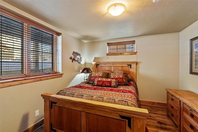 bedroom with dark hardwood / wood-style flooring