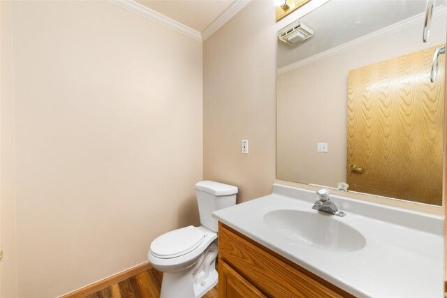 bathroom featuring vanity, toilet, ornamental molding, and wood-type flooring