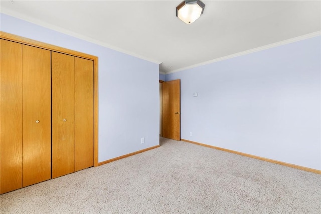 unfurnished bedroom featuring ornamental molding, light carpet, and a closet