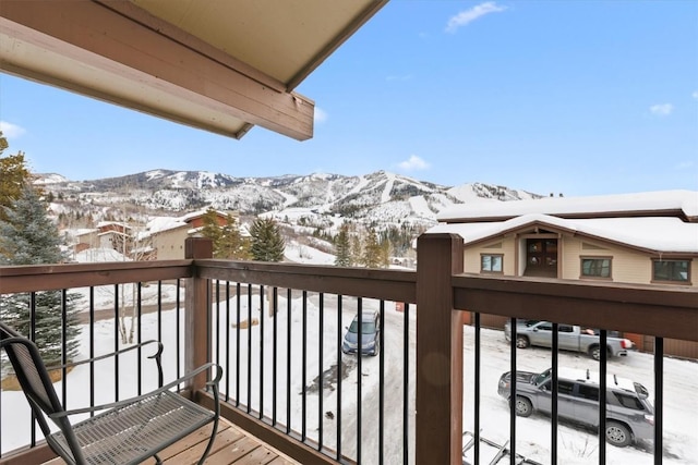 snow covered back of property with a mountain view