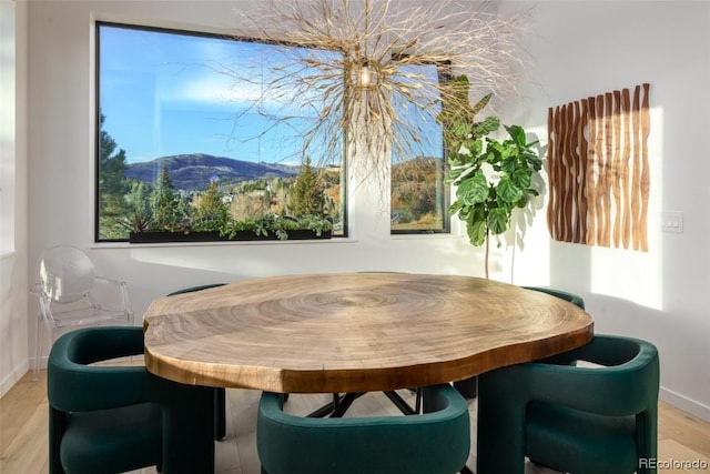 dining space with light wood-type flooring and a mountain view