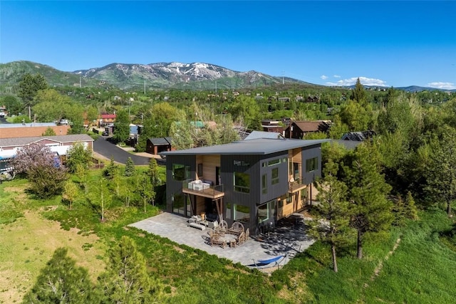 rear view of house featuring a balcony and a mountain view