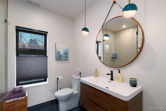 bathroom featuring toilet, vanity, an enclosed shower, and tile patterned floors