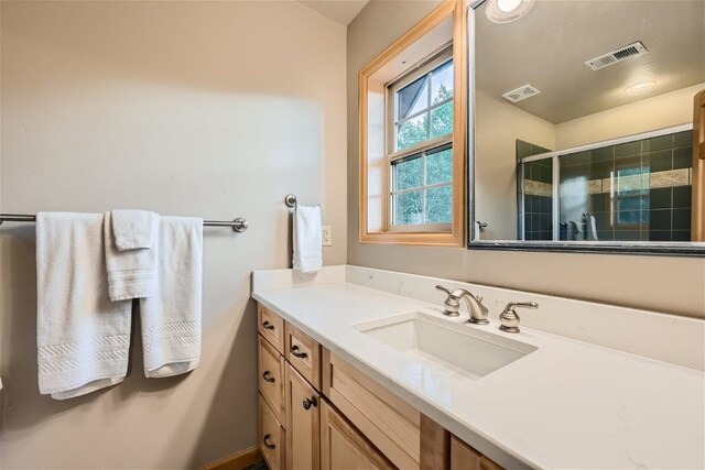 bathroom with vanity and a shower with shower door