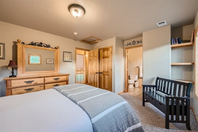 bedroom with light carpet and connected bathroom