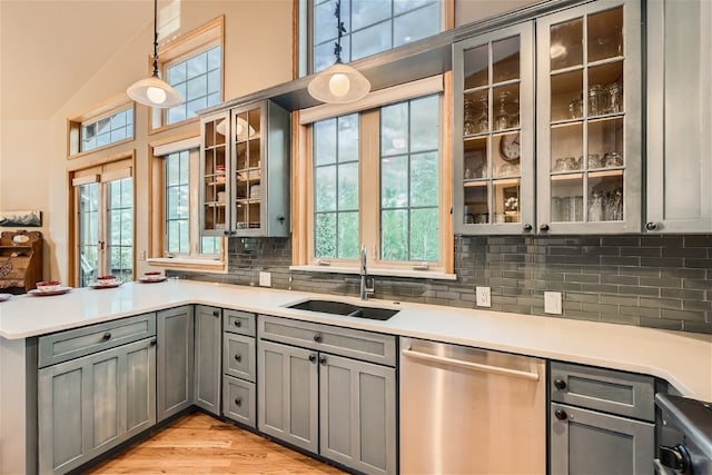 kitchen featuring tasteful backsplash, gray cabinets, sink, and stainless steel dishwasher