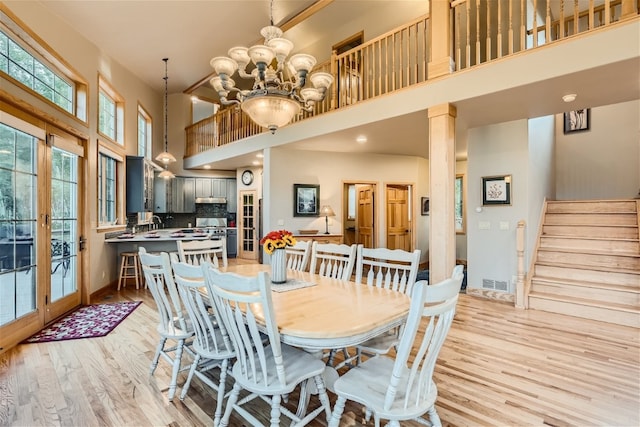 dining space with french doors, a wealth of natural light, and a high ceiling