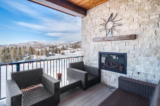 snow covered back of property with a mountain view