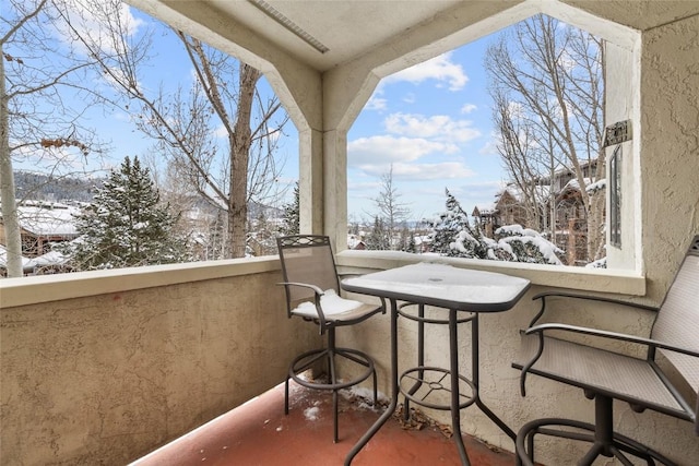 view of snow covered back of property