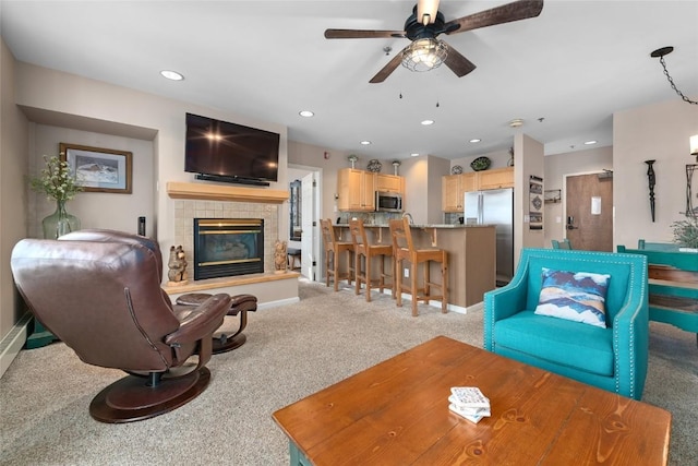 carpeted living room featuring ceiling fan and a fireplace