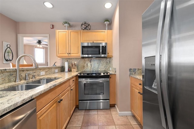 kitchen with stainless steel appliances, ceiling fan, sink, backsplash, and light stone counters