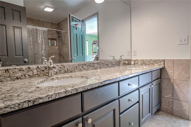 bathroom featuring tile patterned floors, vanity, tile walls, and walk in shower