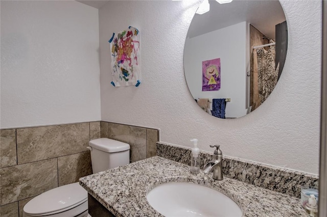 bathroom with curtained shower, vanity, and toilet